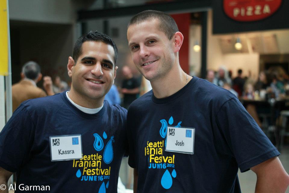Two men wearing shirts that say seattle iranian festival