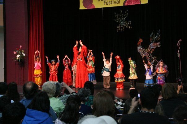 A group of children are performing on a stage at a festival