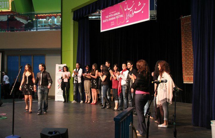 A group of people standing on a stage in front of a sign that says 