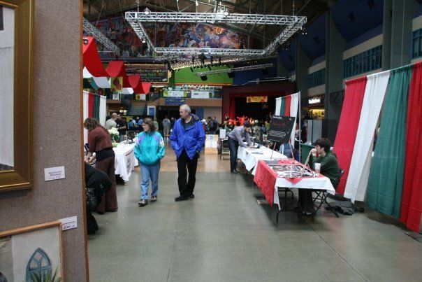 A man in a blue jacket stands in a room with tables