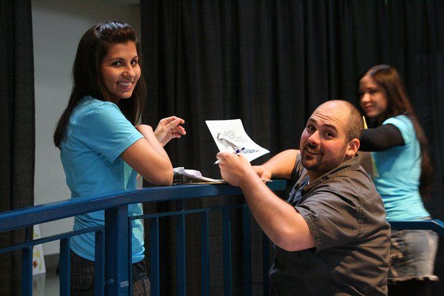 A man and a woman are standing next to each other on a balcony.