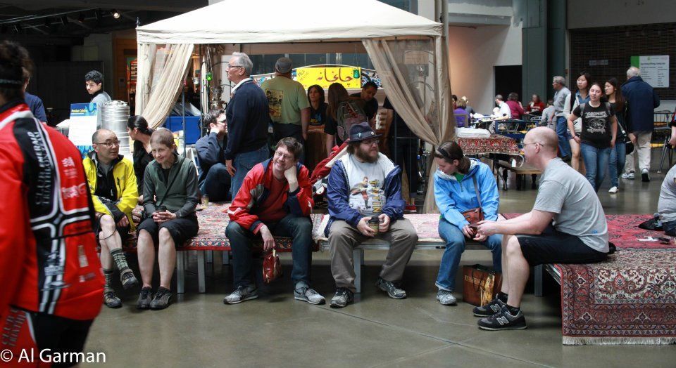 A group of people are sitting under a canopy in a room