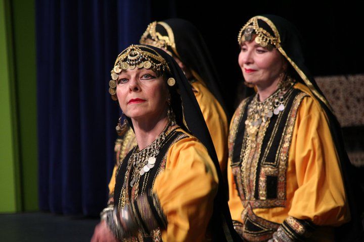 A group of women in traditional costumes are standing next to each other