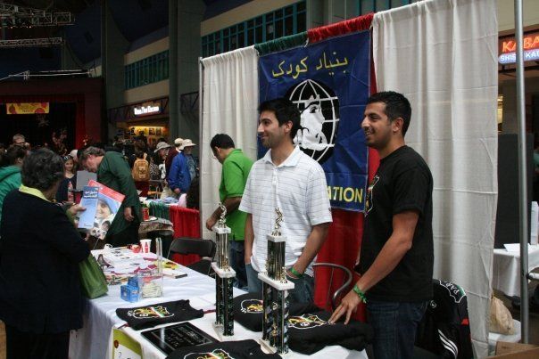Two men standing in front of a table with a sign that says ' nations ' on it