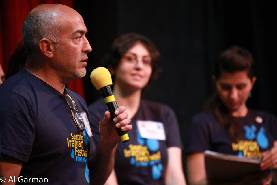 A man is holding a yellow microphone in front of a group of people