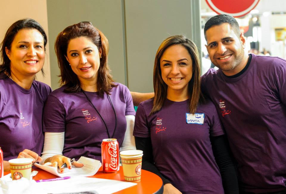 A group of people wearing purple shirts are posing for a picture.