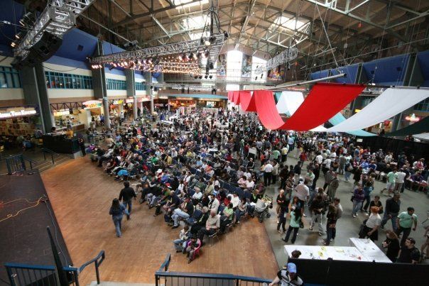 A large crowd of people are gathered in a large building