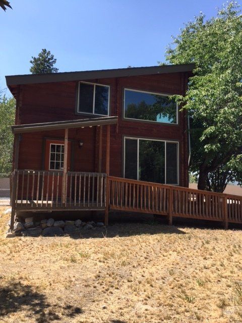 Wooden house with a ramp for accessibility and a covered porch.