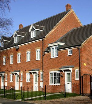 a huge brick wall house with a small garden area