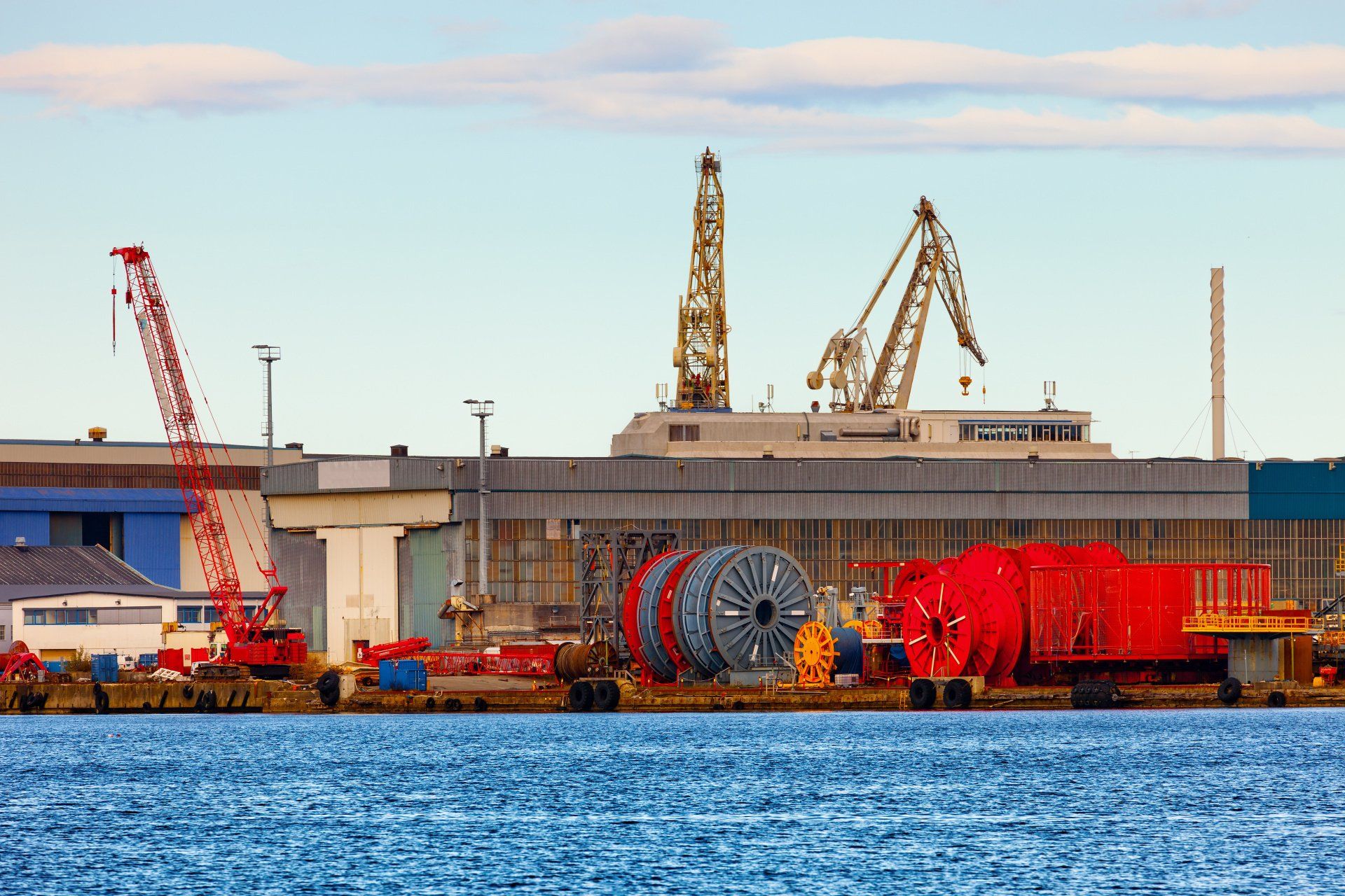 A large body of water is surrounded by buildings and cranes.