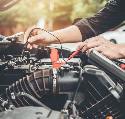 Complete Auto Repair — Mechanic Checking Car Battery in Complete Auto Repair — Mechanic Checking Car Battery in