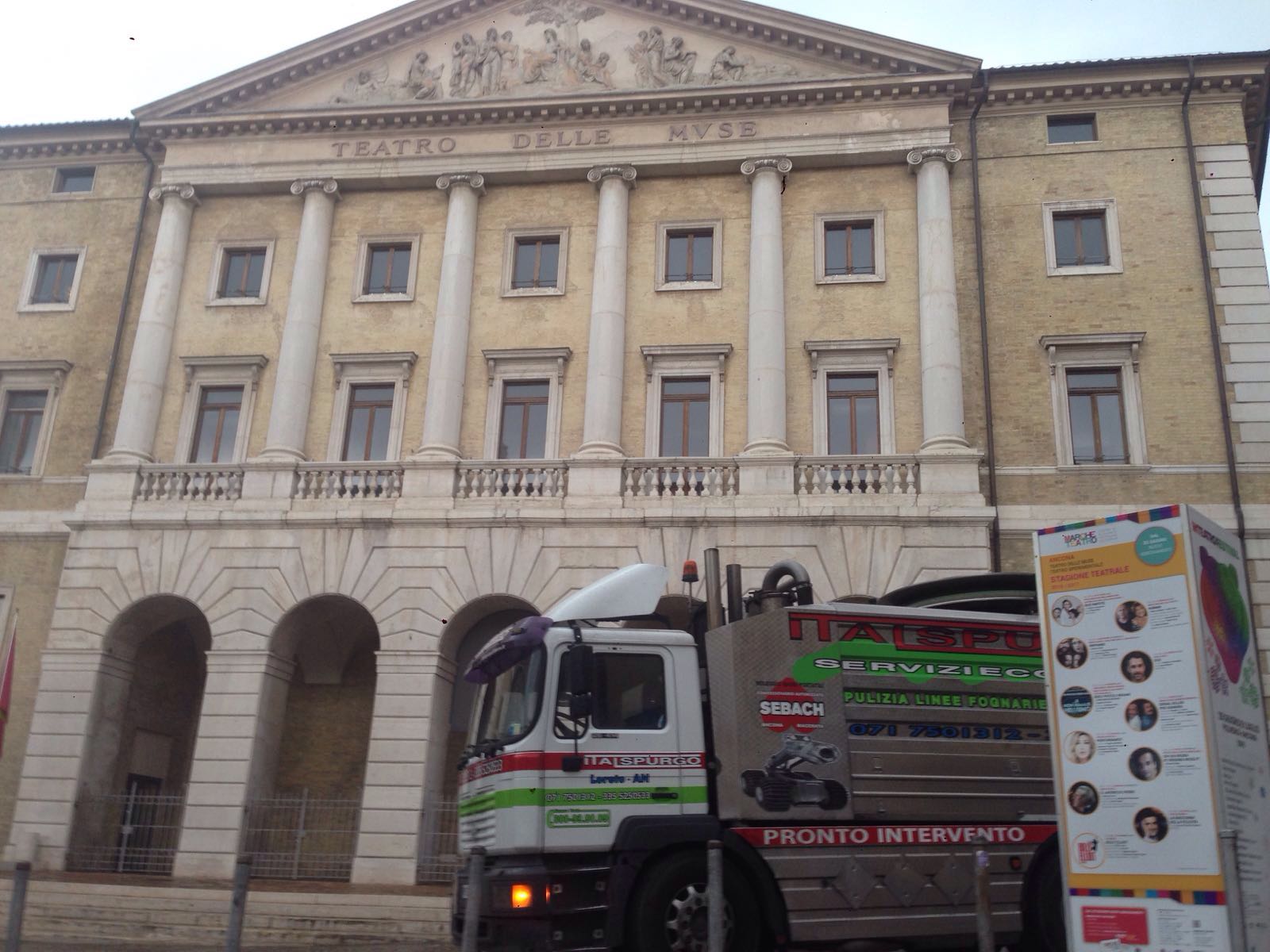 Un camion dei pompieri è parcheggiato davanti a un imponente edificio in pietra con archi e colonne.