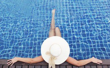 Woman in hat relaxing at Pool—Pool Store in Manorville, NY Woman in hat relaxing at Pool—Pool Store in Manorville, NY