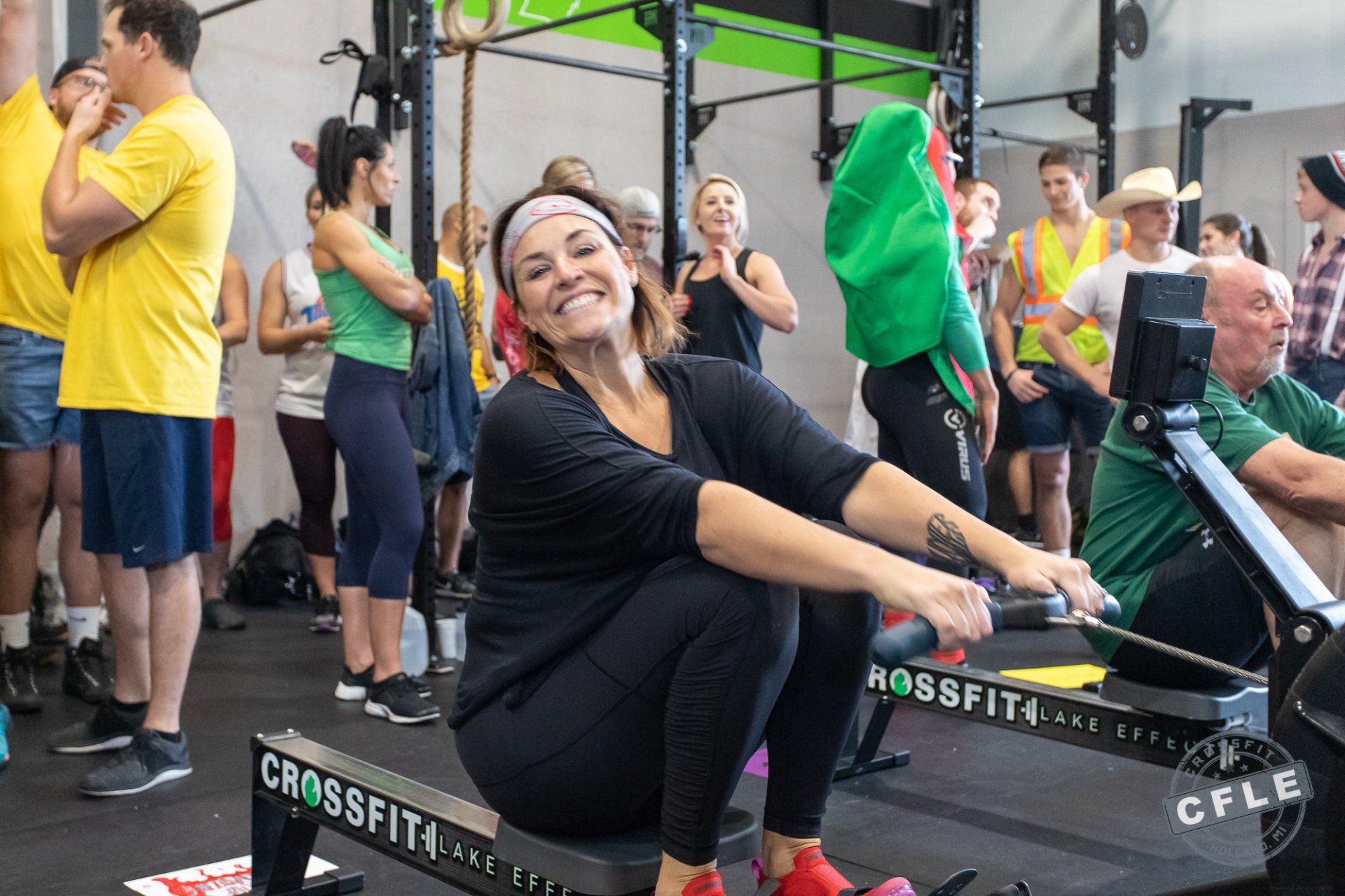 A woman is sitting on a rowing machine in a gym.