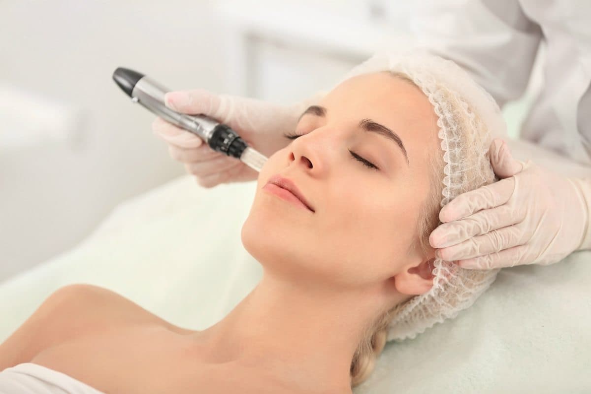 A woman is getting a microdermabrasion treatment on her face.