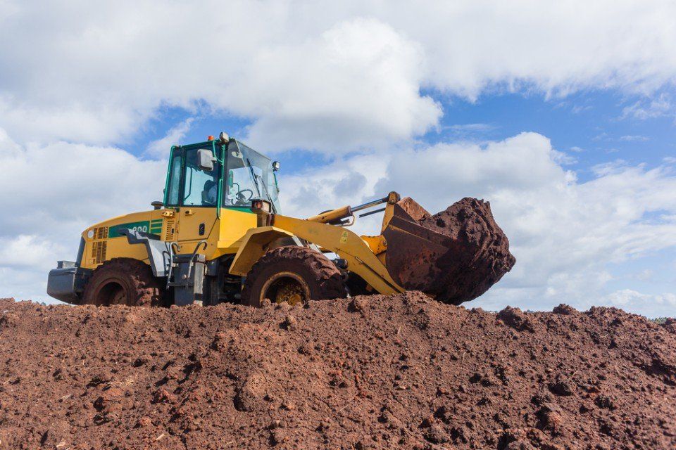 earth-moving machine cleaning the site