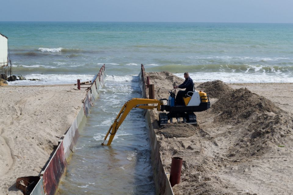 earth moving machine clearing a canal