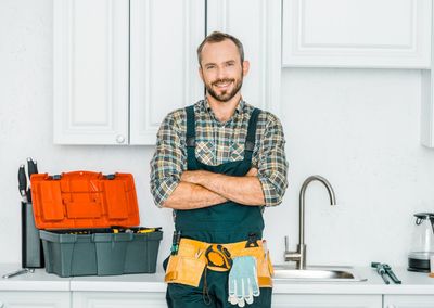 Water Leak Repair — Smiling Plumber in Kitchen in Amarillo, TX