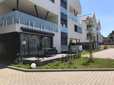 Ein Gebäude mit einem Balkon und einer davor liegenden Terrasse.