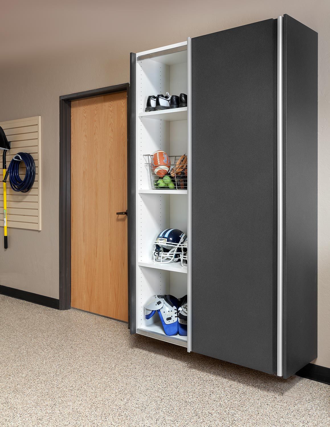 A sliding door cabinet in a garage with shelves and a door.