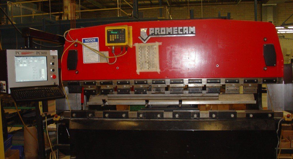 Red industrial press machine with a control panel in a factory setting