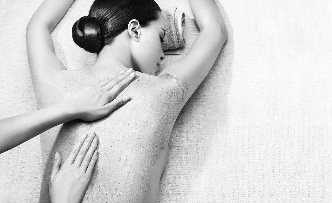 A woman is getting a massage in a black and white photo.