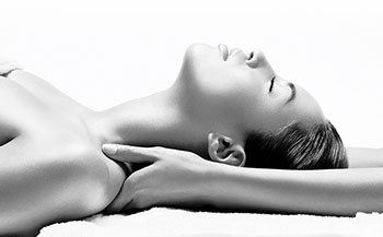 A black and white photo of a woman getting a massage.