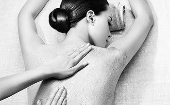 A woman is getting a massage in a black and white photo.