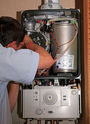 Does you boiler need servicing? Call Croft Heating today An engineer servicing a boiler