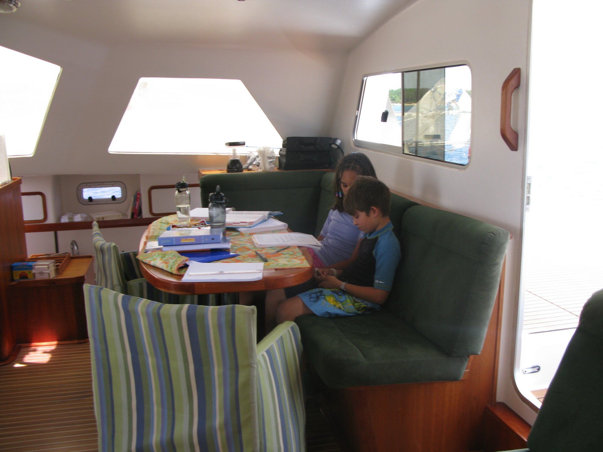 A boy and a girl sit at a table on a boat