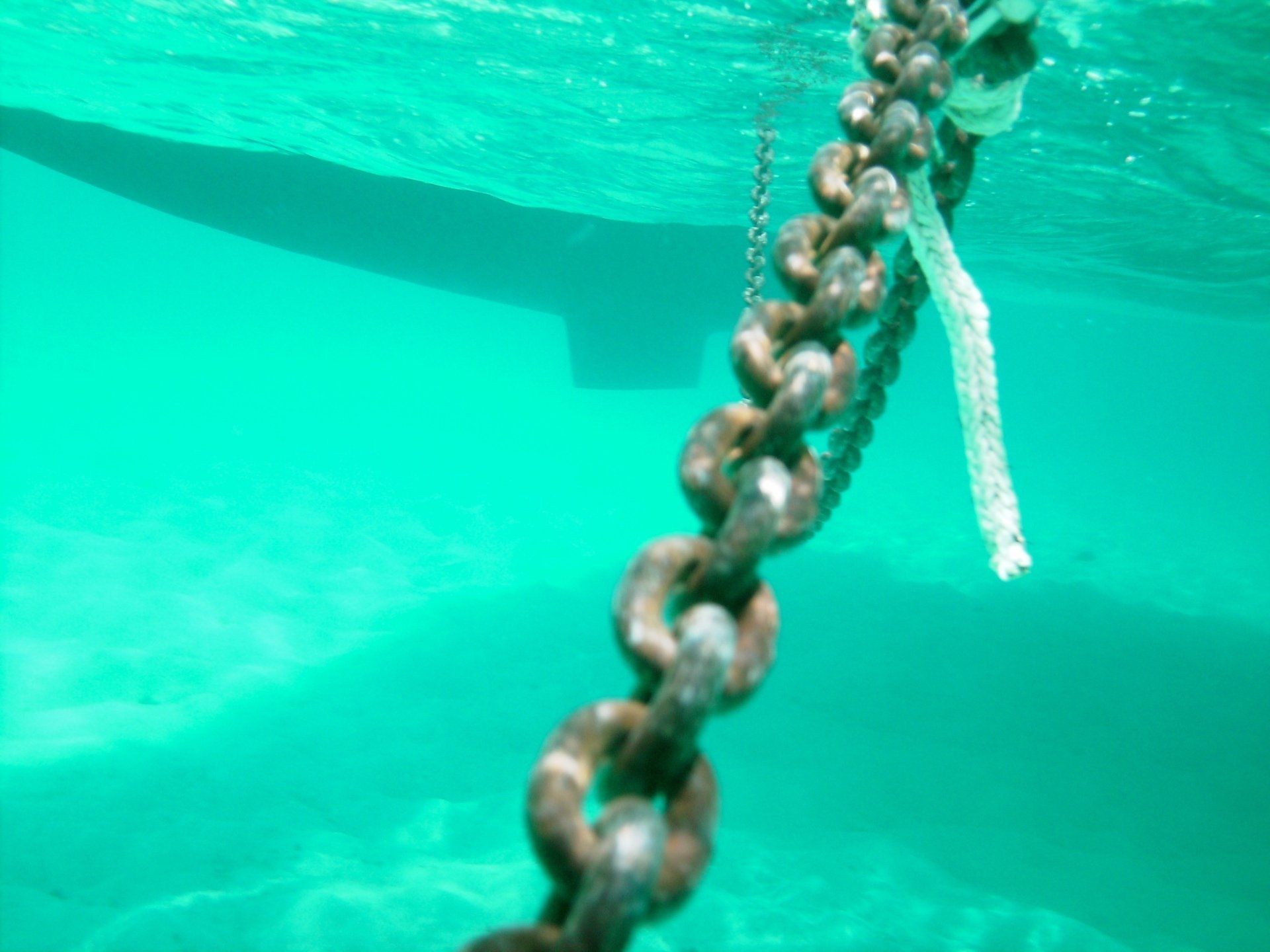 A chain is hanging from the bottom of a body of water