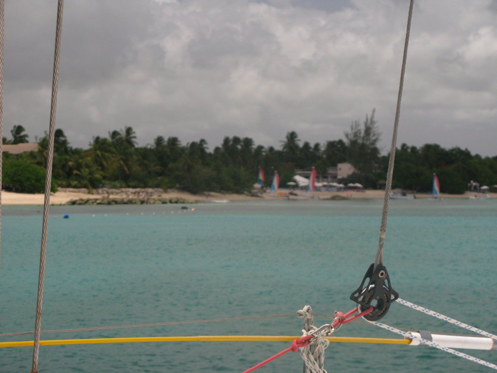 A sailboat in the ocean with a beach in the background