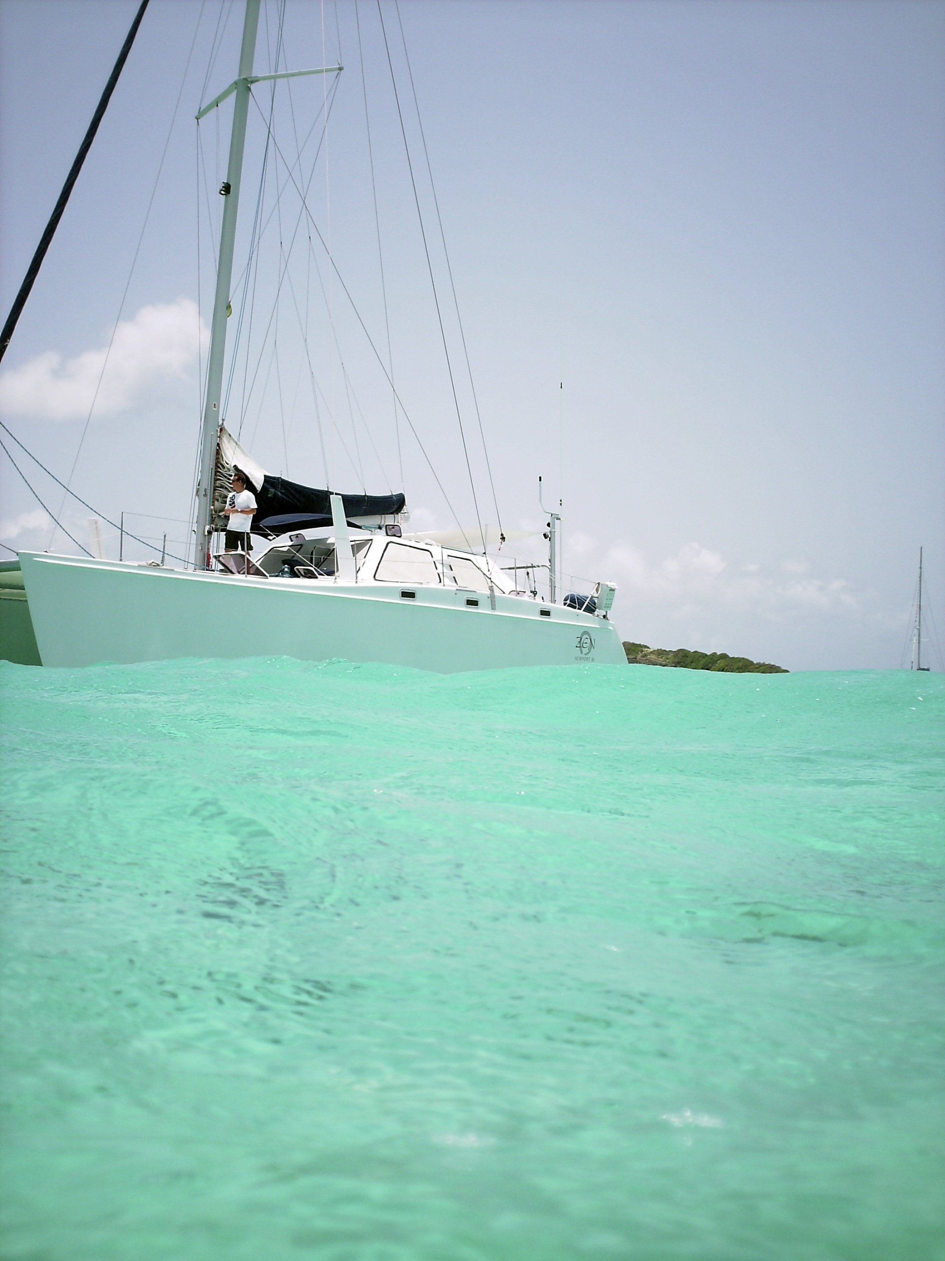 A sailboat is floating in a turquoise body of water