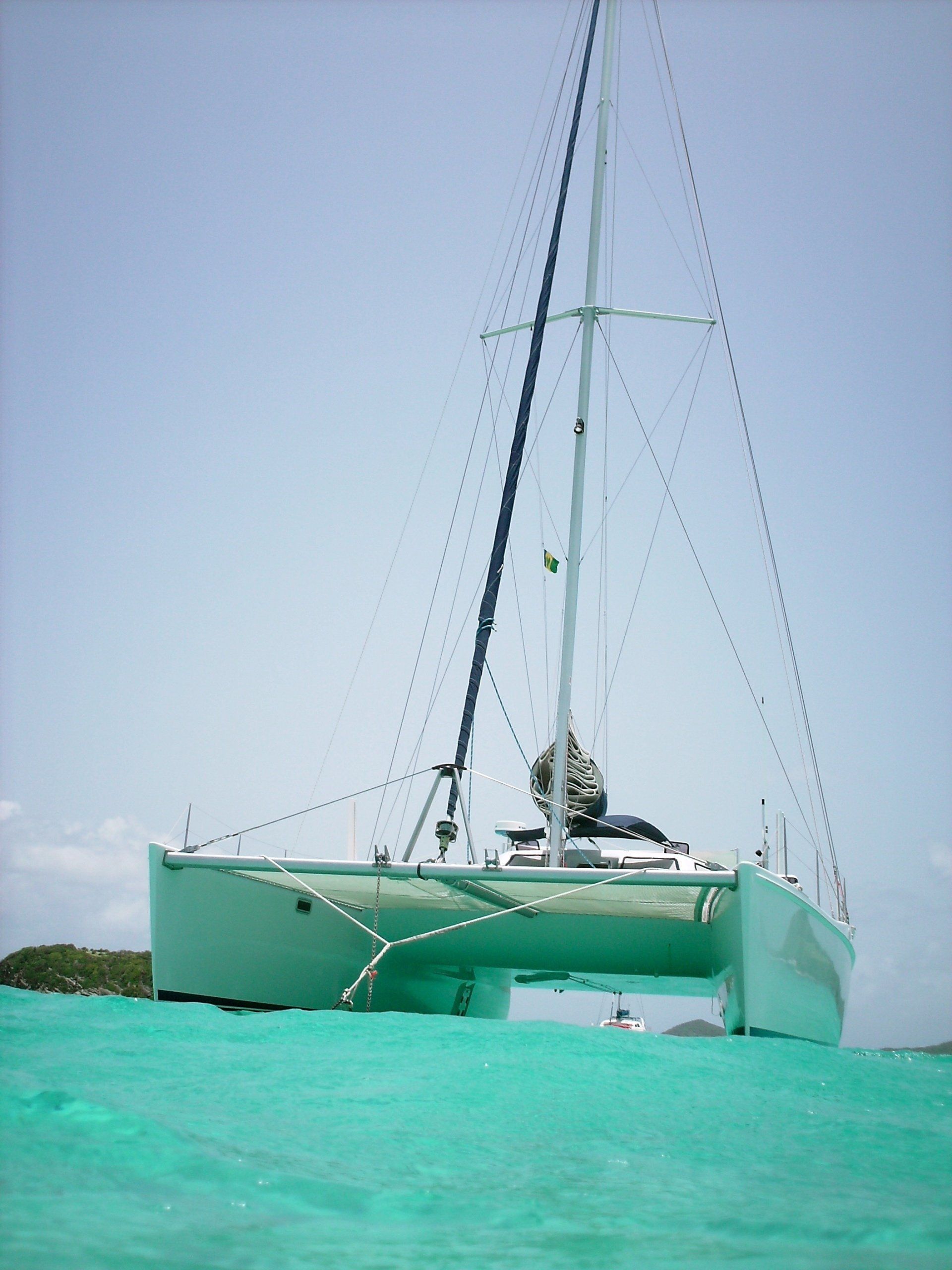 A sailboat is floating on top of a turquoise body of water