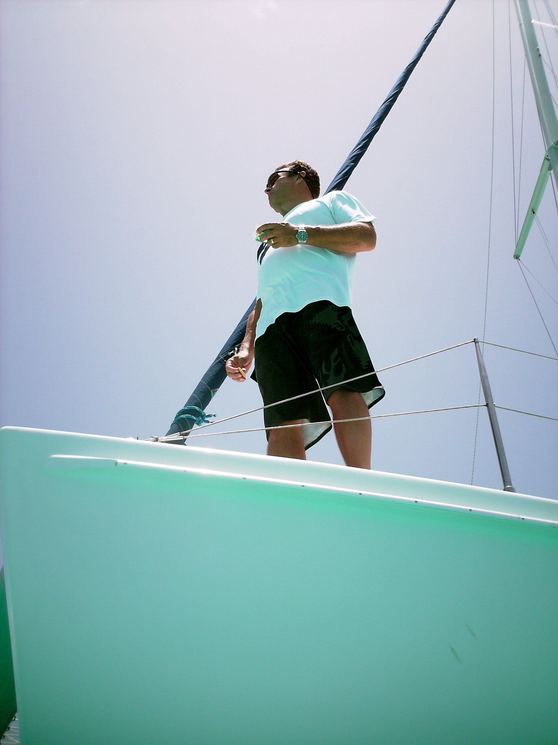 A man standing on top of a green boat