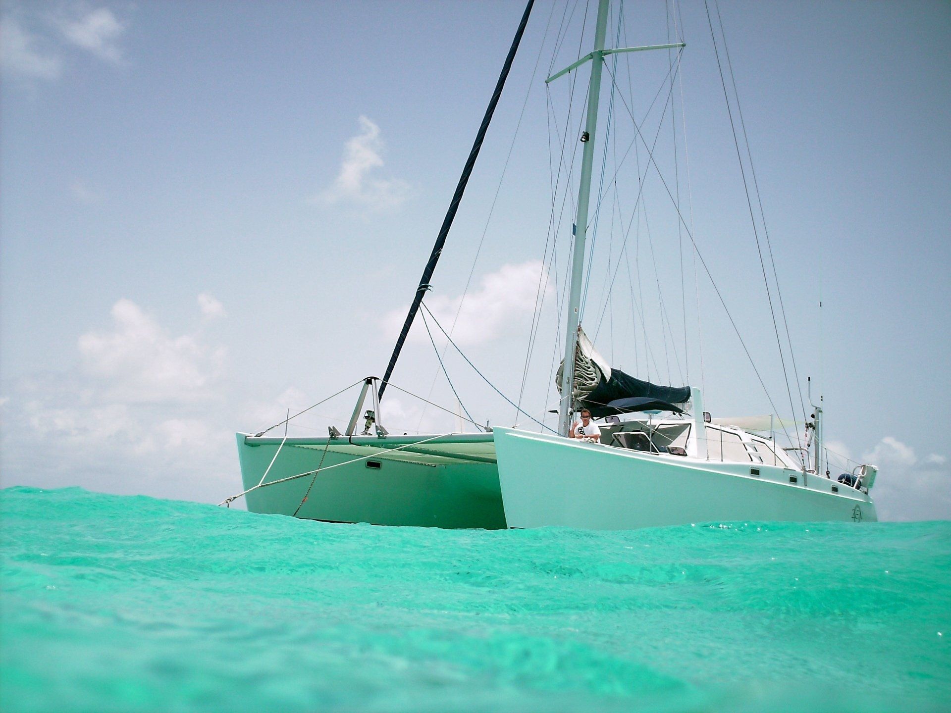 A sailboat is floating on top of a turquoise body of water