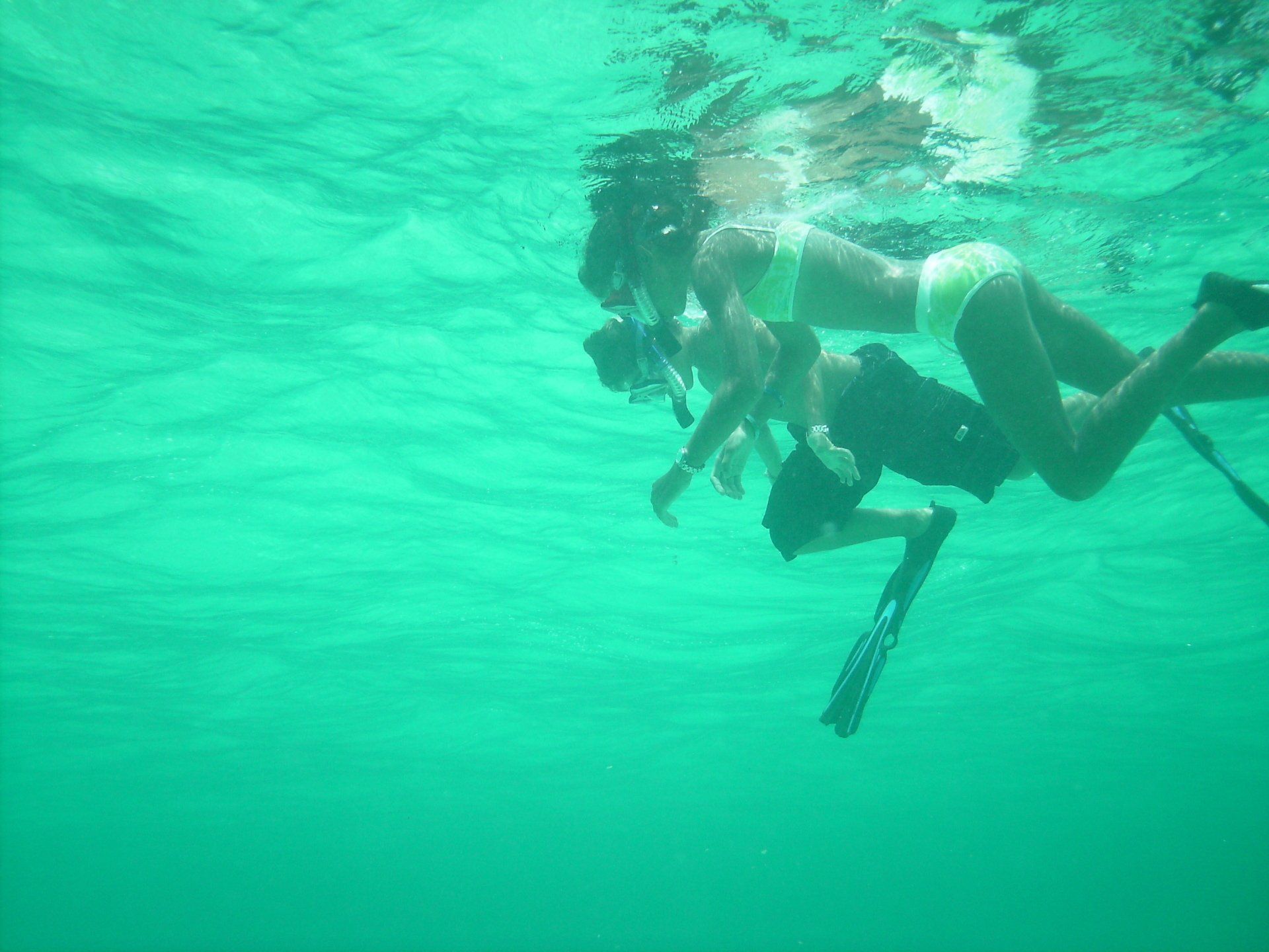 Two women in bikinis are swimming in the ocean