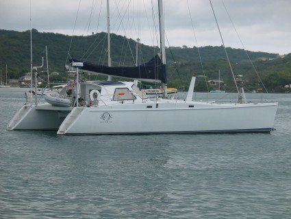 A white sailboat is floating on top of a body of water.