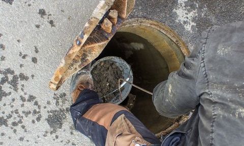 expert removing mud and root from the drainage system