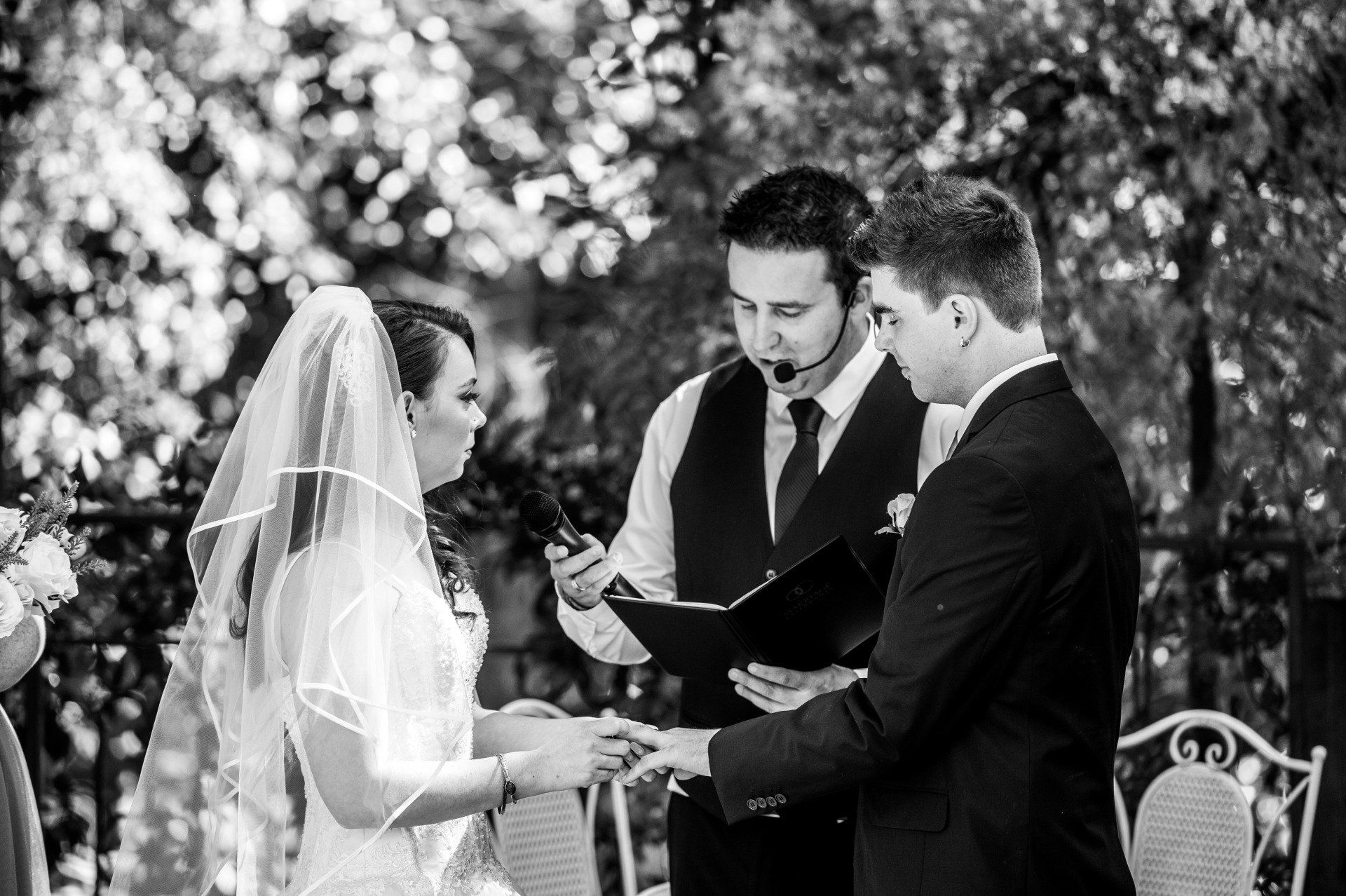 A bride and groom are getting married in a black and white photo.