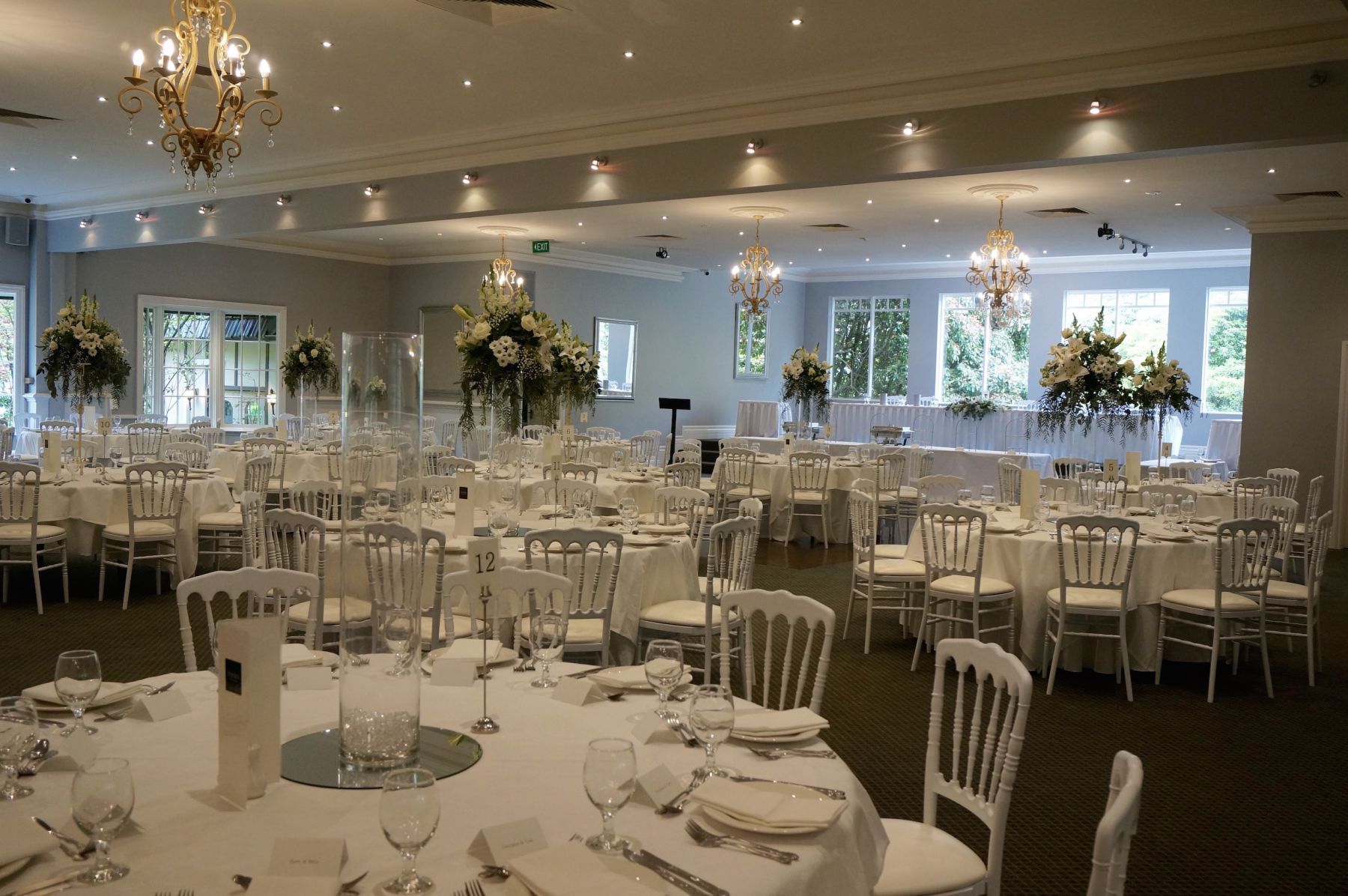 A large room with tables and chairs set up for a wedding reception
