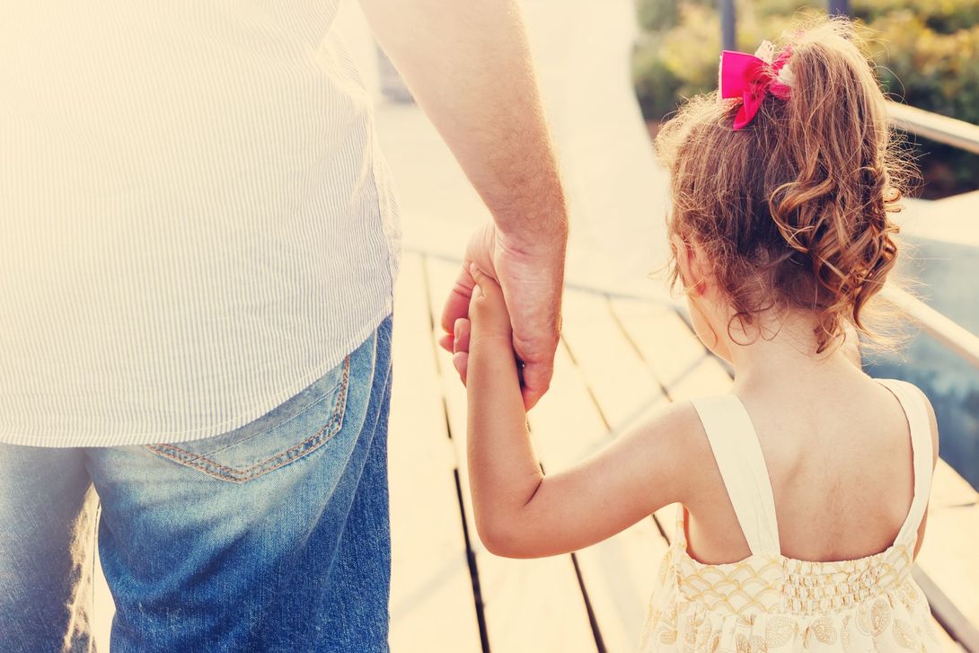 Bambina che dà la mano al papà