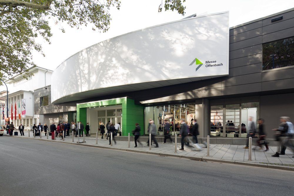 A group of people are walking in front of a large building