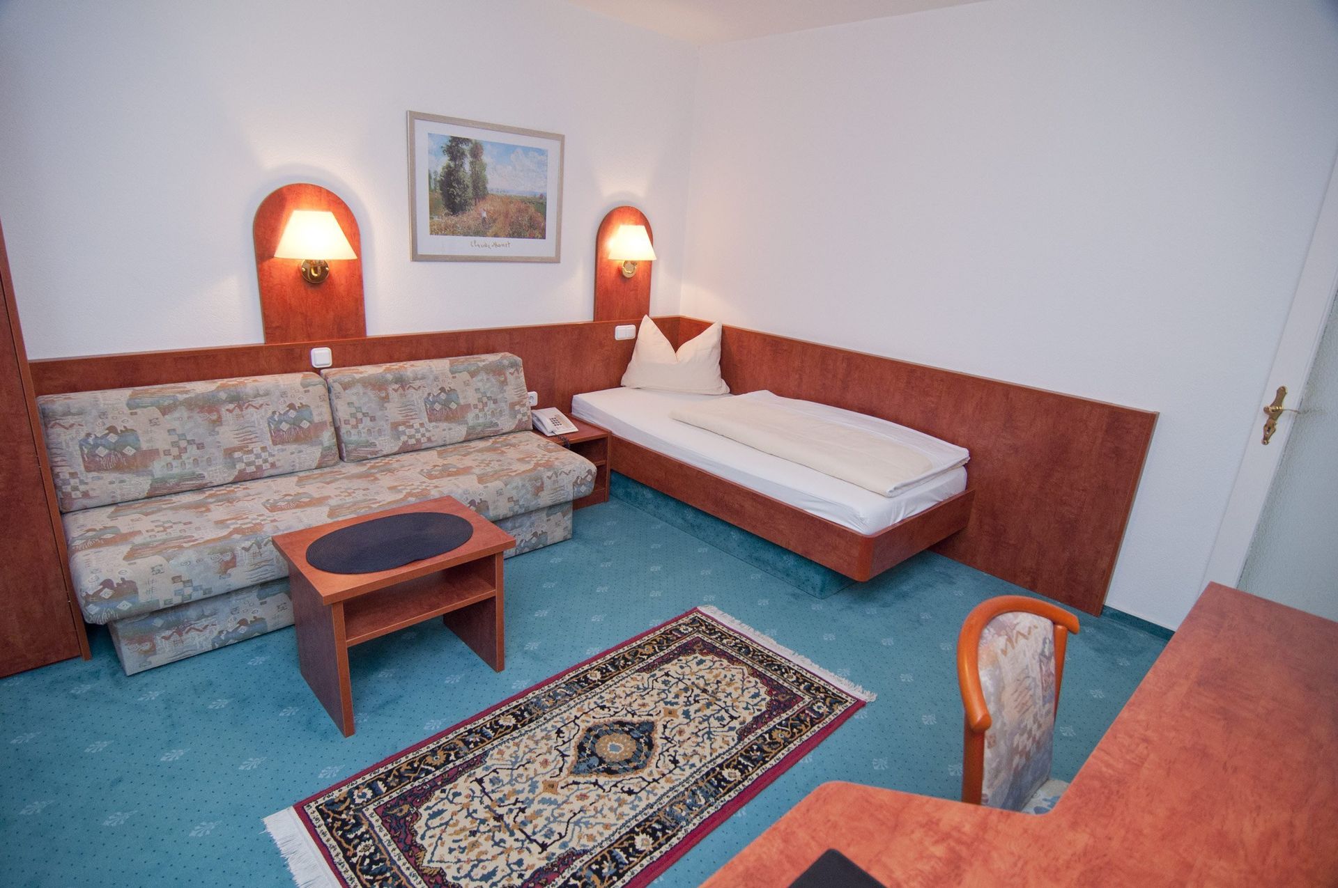 A hotel room with a single bed and a couch