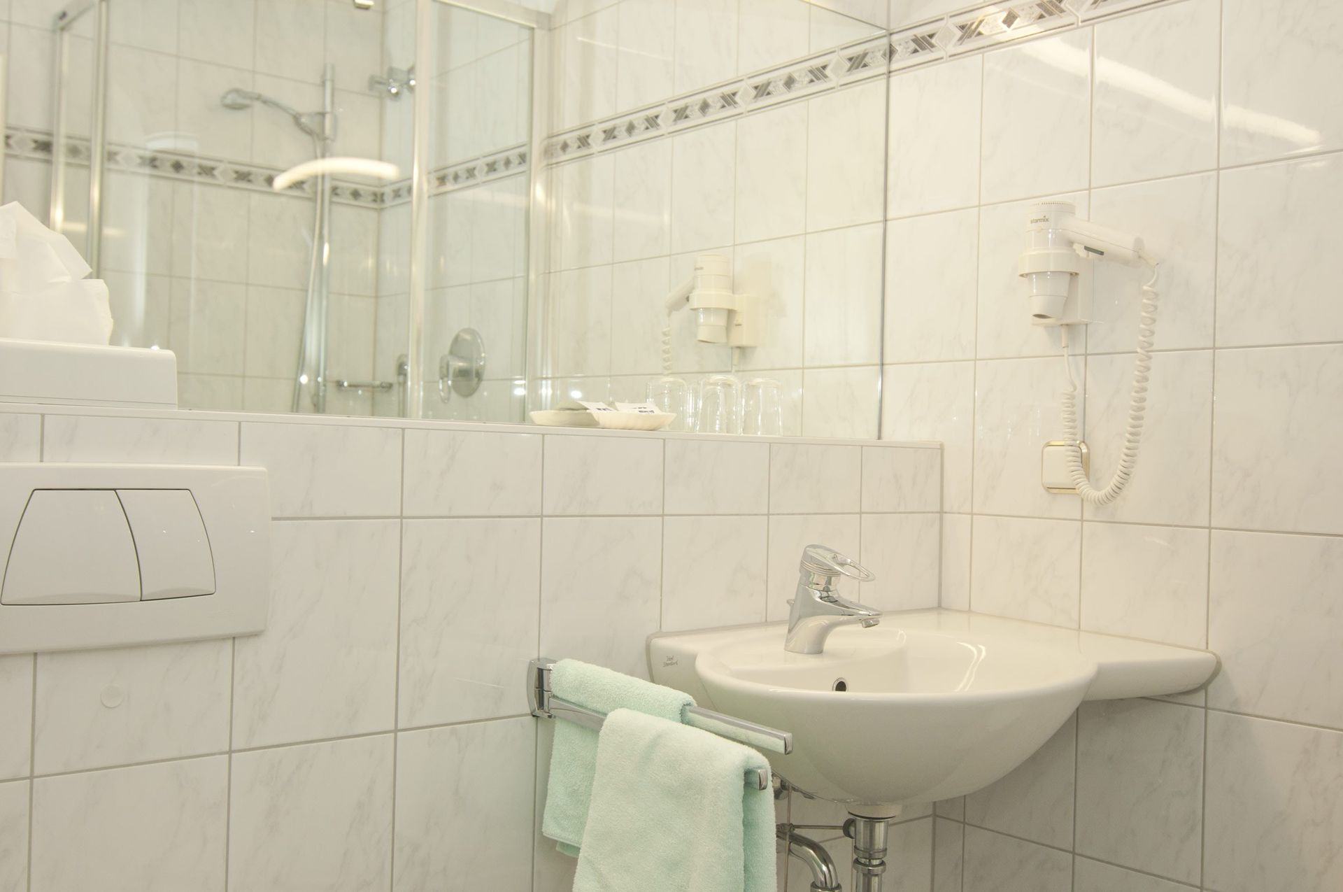 Ein Badezimmer mit Waschbecken, Dusche und Spiegel.
