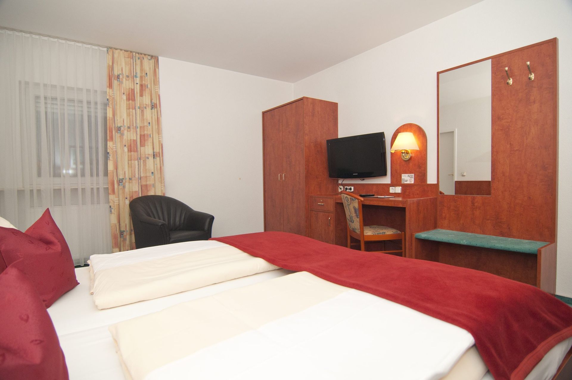 Ein Hotelzimmer mit zwei Betten und einem Fernseher