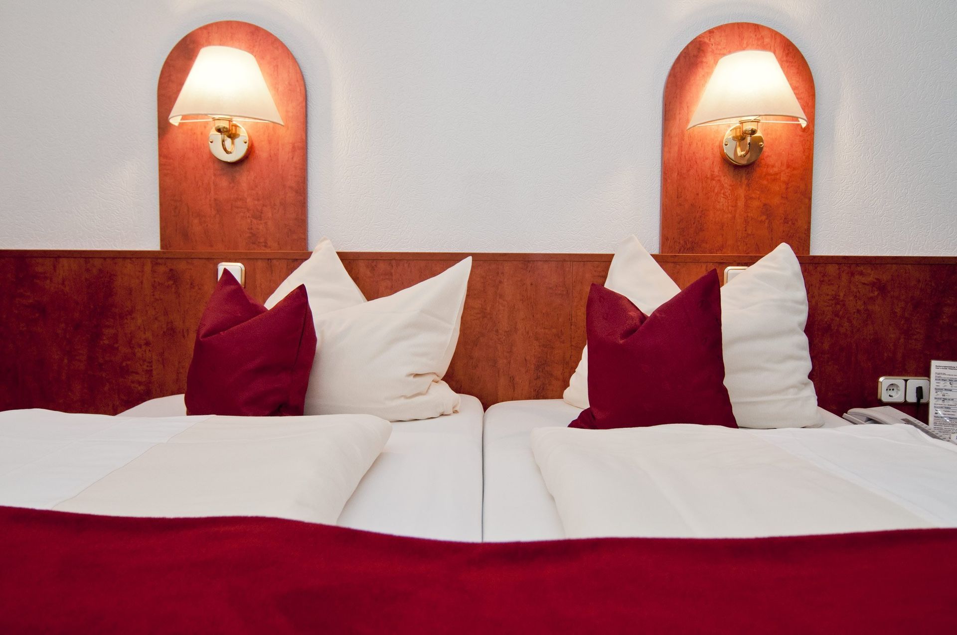 Ein Hotelzimmer mit zwei Betten und zwei Lampen