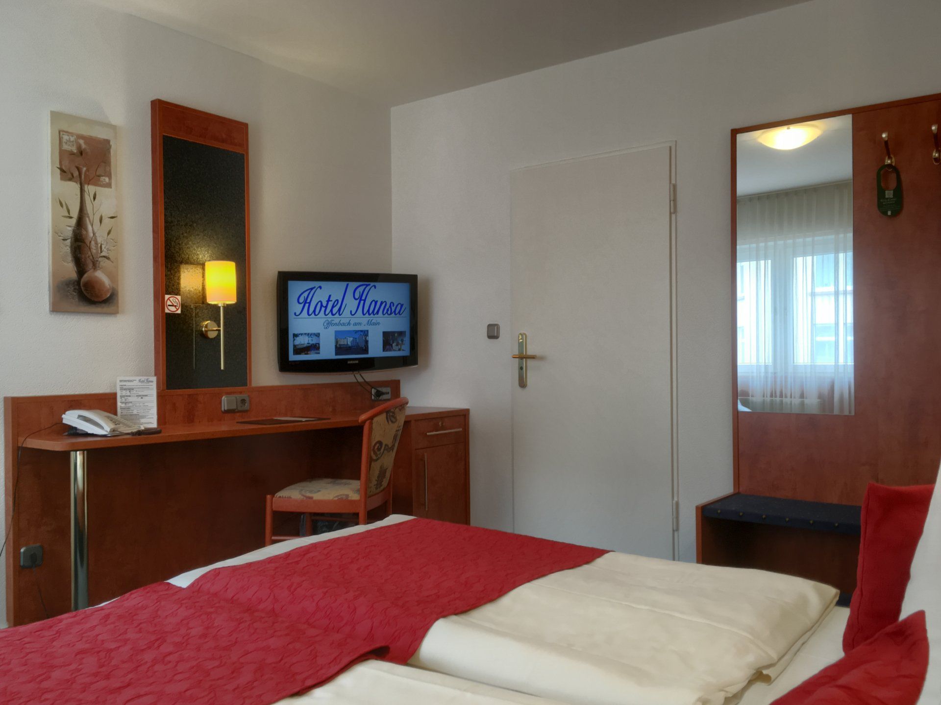 Ein Hotelzimmer mit einem Bett und einem Flachbildfernseher