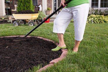 Women Mulching Flowerbed — Mulching in Silver Springs, MD