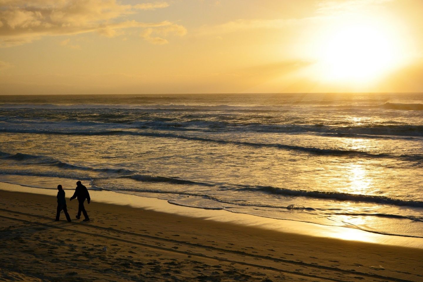 couple walking along the beach at sunset